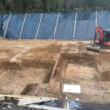 kleiner Bagger hebt Löcher aus