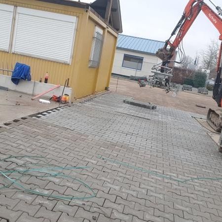 Kleiner Bagger mit Pfalstersteinen