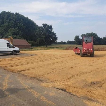 roter Bagger mit einer Walze